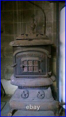 Antique wood burning stove round oak duplex cast iron with pipes and accessories